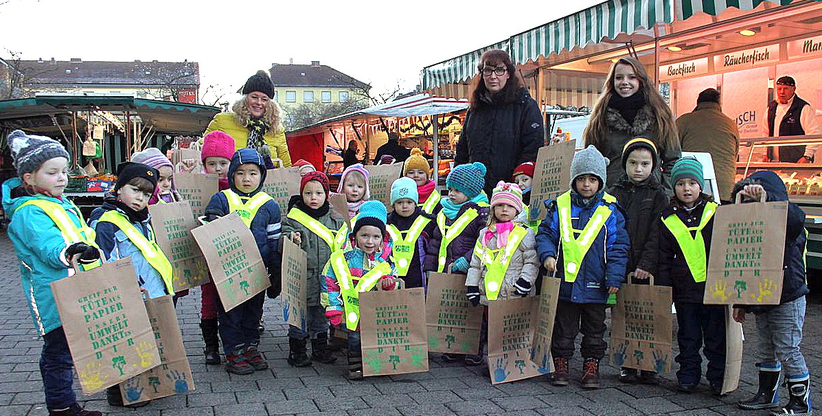 Die Kinder der KiTa am Marienhospital werben mit ihren Erzieherinnen auf dem Wochenmarkt am Gutenbergplatz für Papiertüten statt Plastiktüten. (Foto: Stadt Arnsberg)