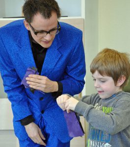 Zauberkünstler Christian Bach zaubert mit einem Kind aus der Kindergruppe „Die Stoppelhopser“ der Kindertagesstätte Zipfelmütze. (Foto: Klinikum)
