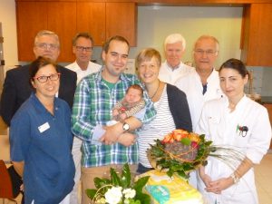 Drei Chefärzte, Klinikum-Geschäftsführer, Hebamme und stationsschwester gratulieren dem Jubiläumsbaby und seinen Eltern. (Foto: oe)