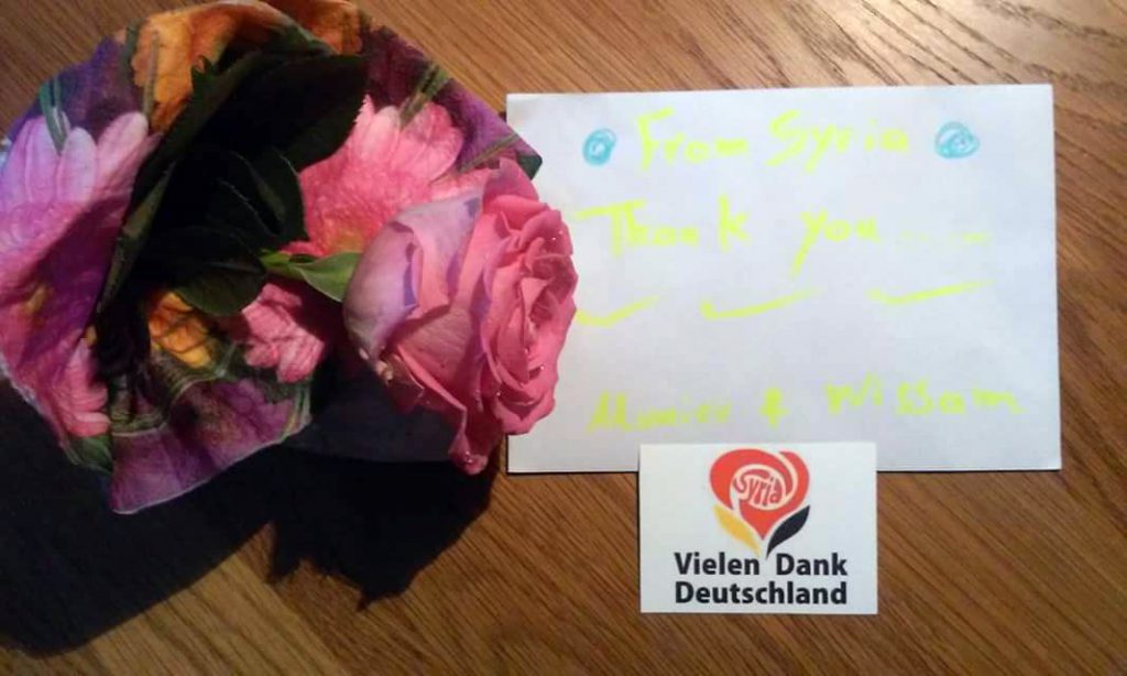 Verteilten Flüchtlinge an alle Helfer: ein Dankesbrief und eine Rose (Foto: DRK)