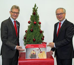 Die Sparkassen-Vorstände Norbert Runde (l.) und Ernst-Michel Sittig präsentieren den neuen Glücksboten-Adventskalender. (Foto: Sparkasse)