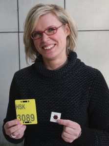 Melanie Mönig von der Unteren Landschaftsbehörde des HSK stellt das gelbe Reitkennzeichen und die neue braune Plakette für 2016 vor (Foto: Pressestelle HSK)