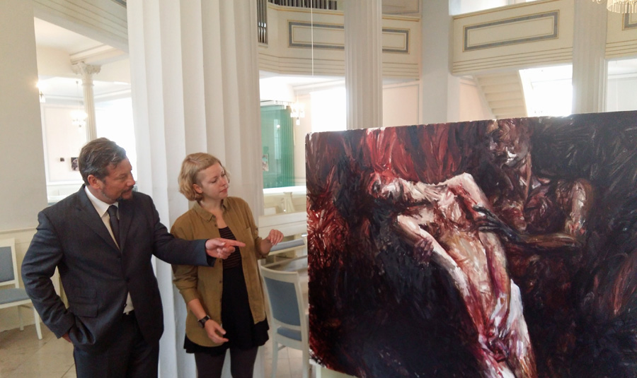 Künstlerin Lioba Schmidt und Pfarrer Johannes Böhnke vor einem der 14 Bilder der Ausstellung "echt ausgezogen" in der Auferstehungskirche. (Foto: oe)